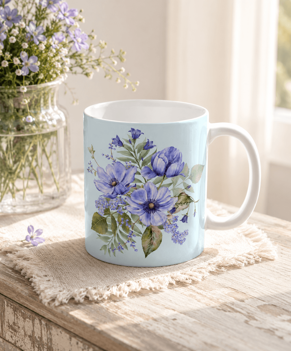 Light blue mug with a hand-painted blue anemone and wildflower bouquet, styled with fresh purple flowers on a rustic wooden table