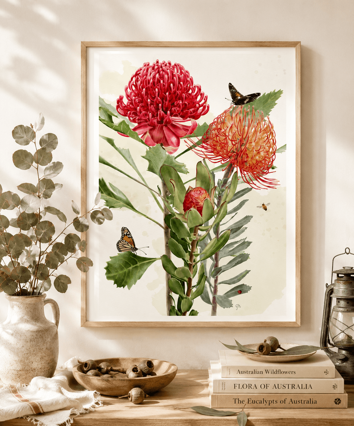Framed Australian waratah and pincushion protea watercolour art print with butterflies, above a rustic console table