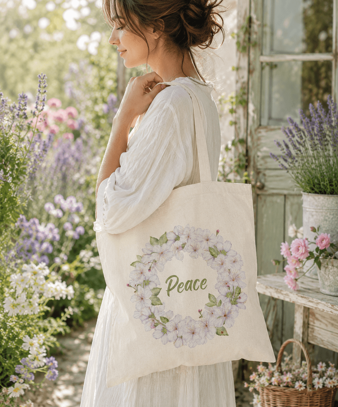 Woman carrying a natural canvas tote bag with a hand-painted white blossom wreath and the word "Peace"