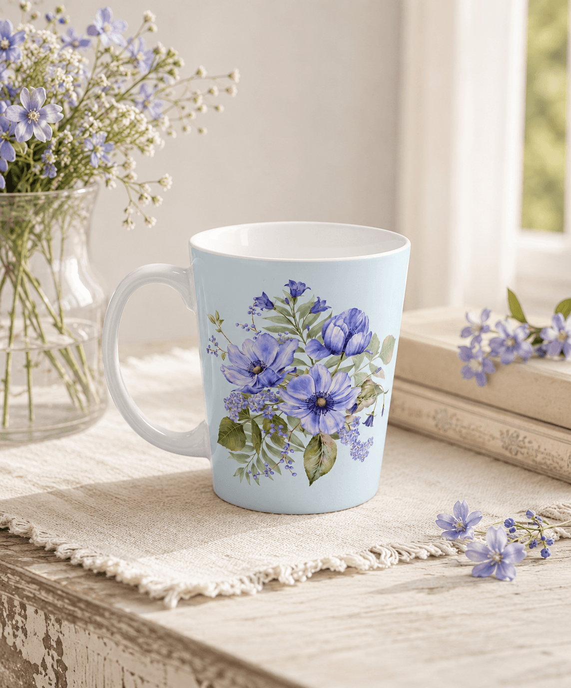 Light blue tapered mug with a hand-painted purple anemone and wildflower bouquet, styled with fresh purple flowers on a wooden windowsill